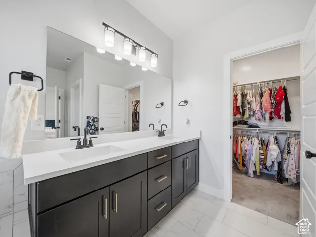 Dual vanity with dark wood-finish cabinetry, white countertop, and integrated sinks