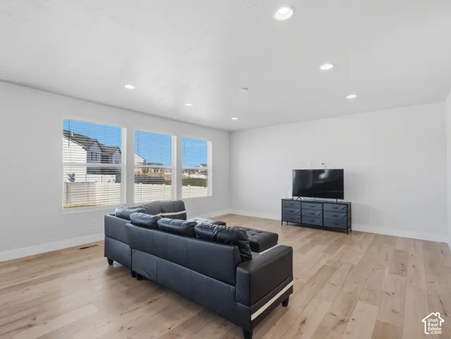 Recessed lighting illuminates wood-finish flooring