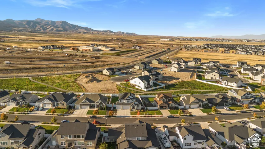 Aerial perspective of a developing residential community, featuring consistent architectural styles and mountain backdrops
