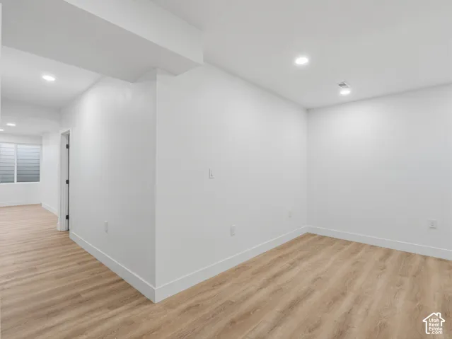 Recessed lighting, wood-finish flooring, white walls, and white trim