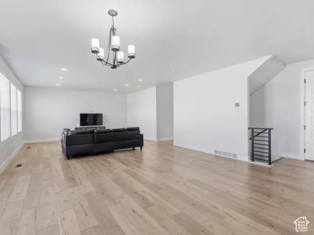 Wood-finish flooring, recessed lighting, and a contemporary chandelier