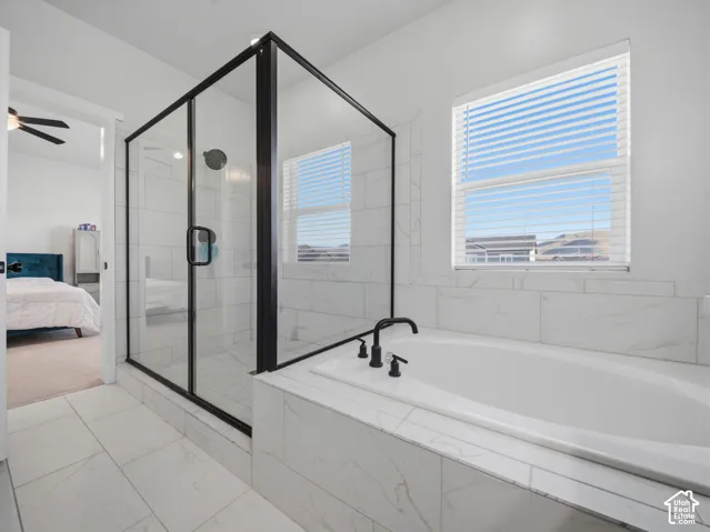 Built-in soaking tub with matte black fixtures, framed glass shower, and large format tile flooring