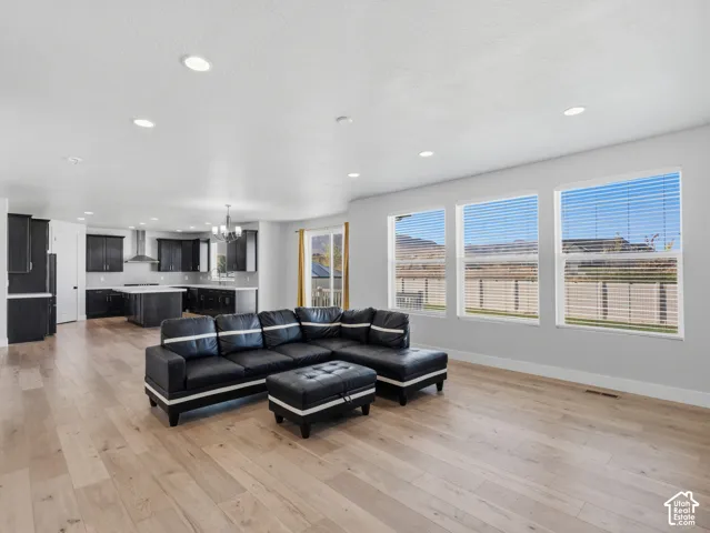 Open-concept living area featuring wood-finish flooring, recessed lighting, and multiple windows