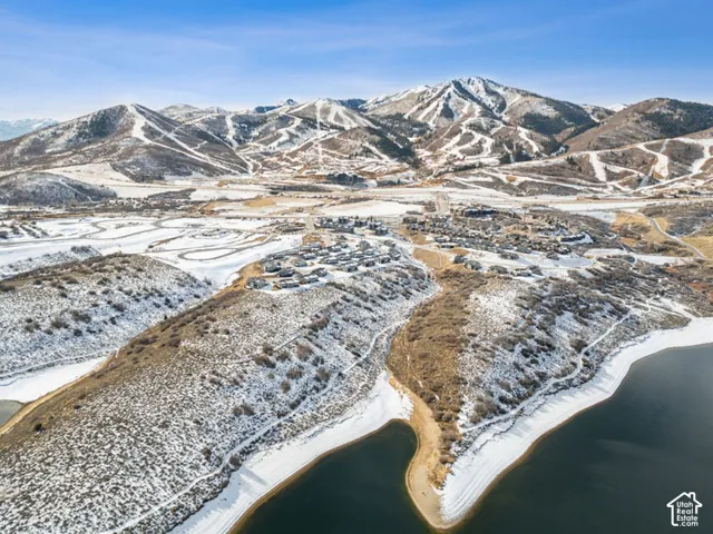Expansive mountain and water scenery with a residential development along the shore