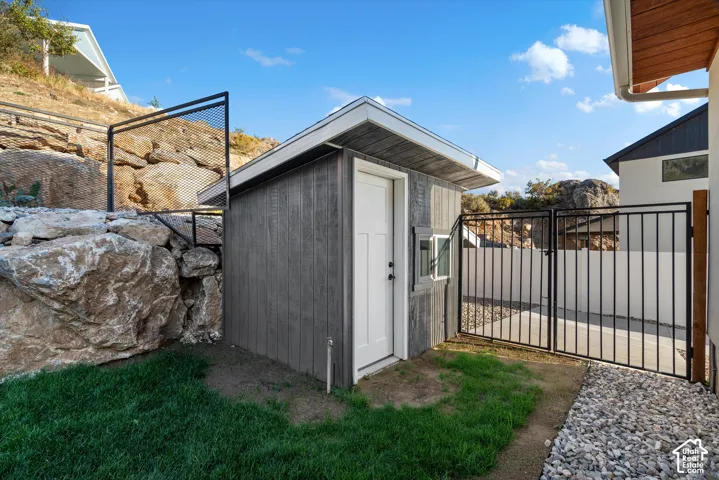 Standalone shed with wood-finish siding, white trim, and a white door