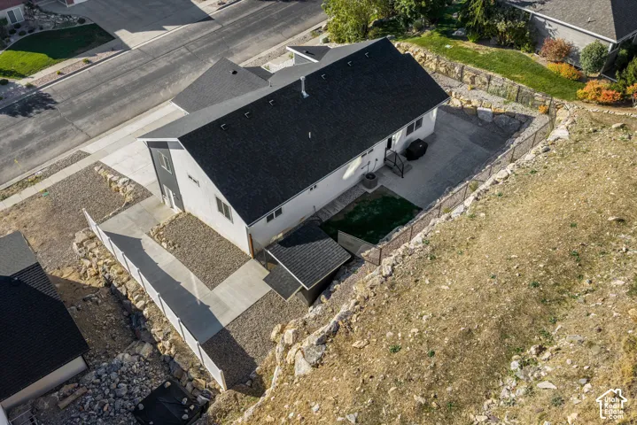 Modern exterior architecture with dark shingles, light siding, and a stone retaining wall