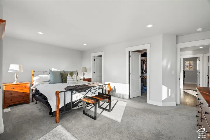 Recessed ceiling lighting, light gray wall paint, gray carpet flooring, white trim, and white interior doors