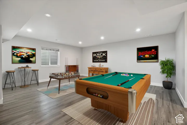 Recessed lighting, wood-finish flooring, and a window with horizontal blinds