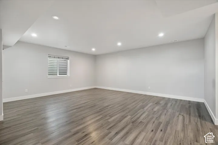 Recessed lighting, wood-finish flooring, white trim, and light gray walls