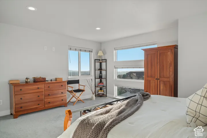 Recessed ceiling lighting, light gray wall paint, carpeting, and multiple windows