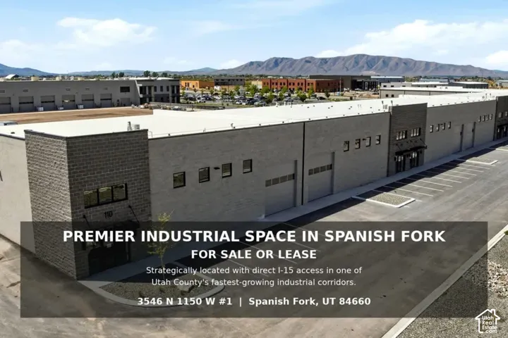 Industrial building with a flat roofline, multiple roll-up doors, and ample paved parking