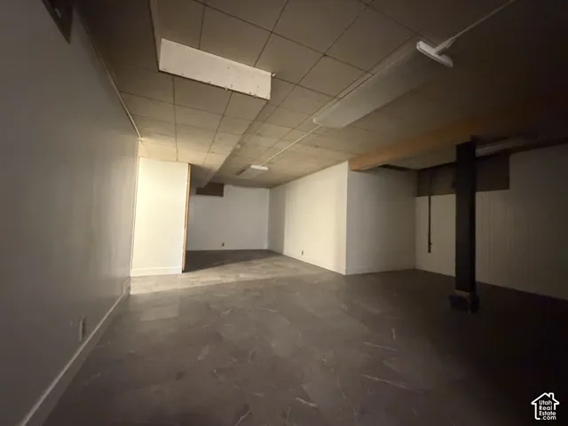 Finished flooring, neutral wall paint, overhead fluorescent lighting, exposed ceiling beam