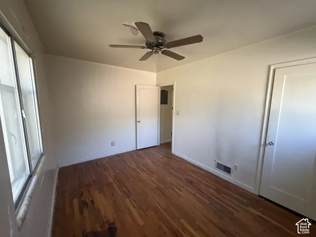 Wood-finish flooring with a ceiling fan and a window
