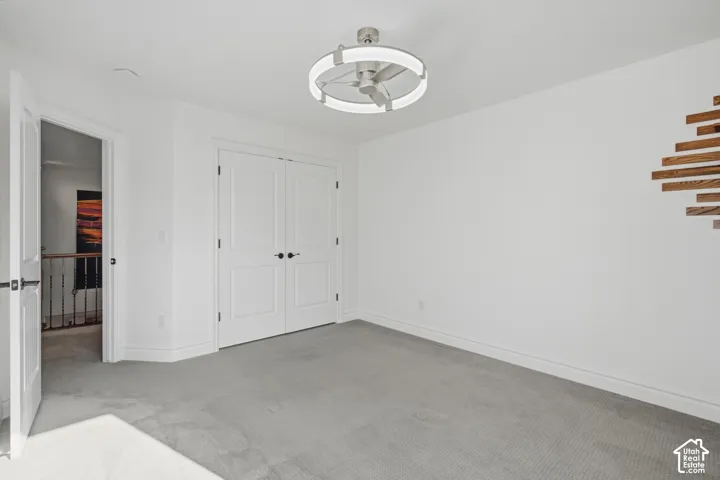 Room featuring neutral carpet, double-panel doors with matte black hardware, and a contemporary circular flush-mount ceiling fixture with integrated lighting