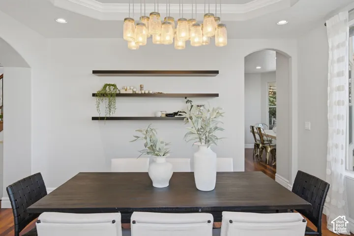 Tray ceiling, multi-light mason jar chandelier, three dark-finish floating shelves, and arched passage entryways