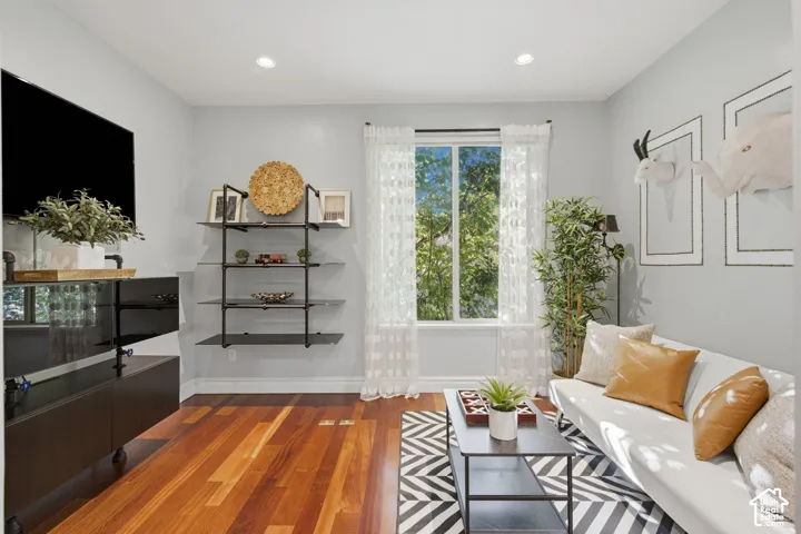 Wood-finish flooring, recessed lighting, and wall-mounted shelving unit with metal supports