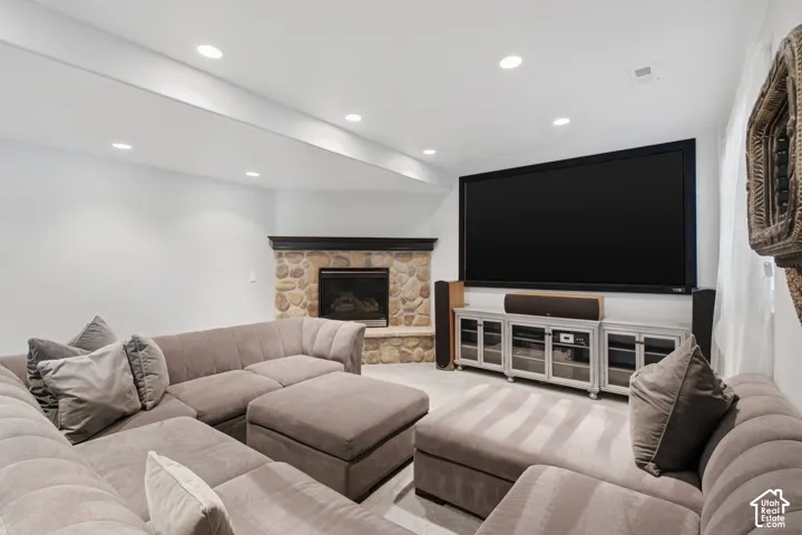Corner fireplace featuring natural stone masonry and a dark wood mantel, complemented by recessed ceiling lighting