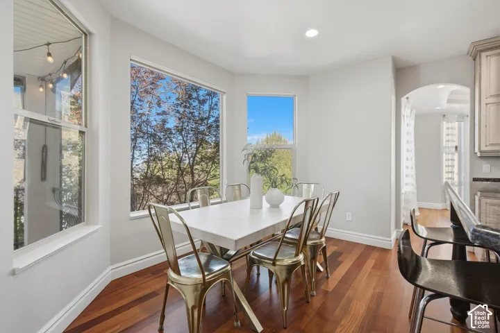 Bay window featuring large picture windows, wood-finish flooring, recessed lighting, and an arched doorway