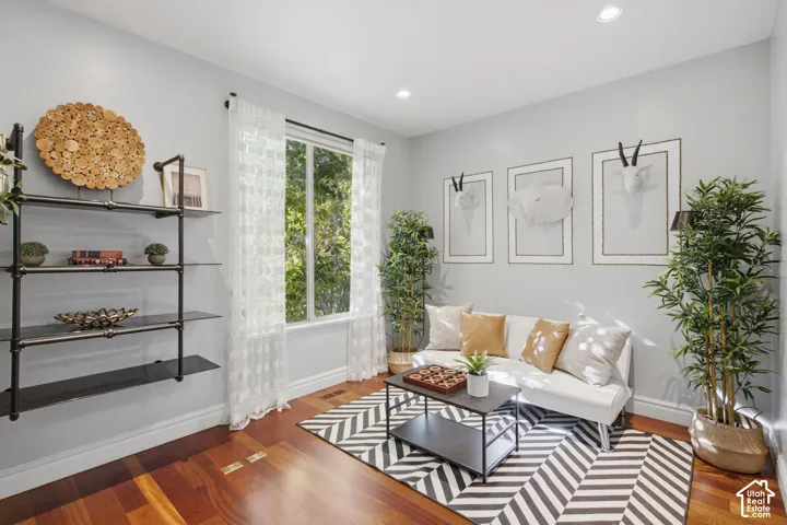 Room featuring wood-finish flooring, recessed lighting, and a large window