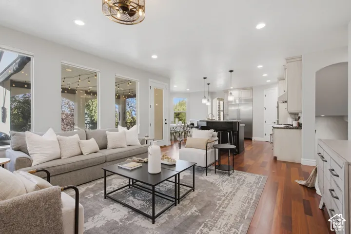 Open-concept floor plan featuring wood-finish flooring, recessed lighting, expansive windows, and a kitchen equipped with stainless steel appliances and a center island