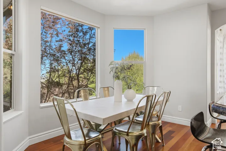 Bay window featuring large picture windows, wood-finish flooring, and neutral wall tones