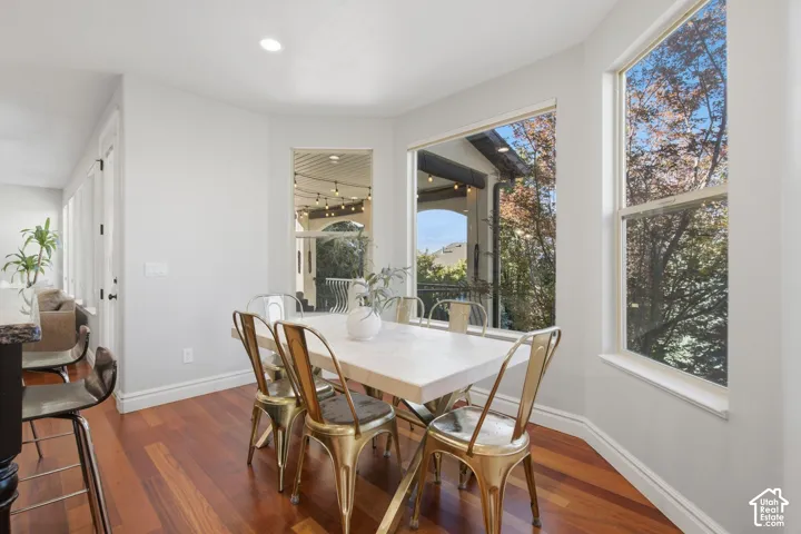Bay window with multiple windows, recessed ceiling lighting, and wood-finish flooring