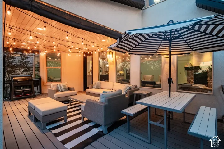 Expansive deck with a slatted wood ceiling, string lighting, and direct access to interior spaces through large windows