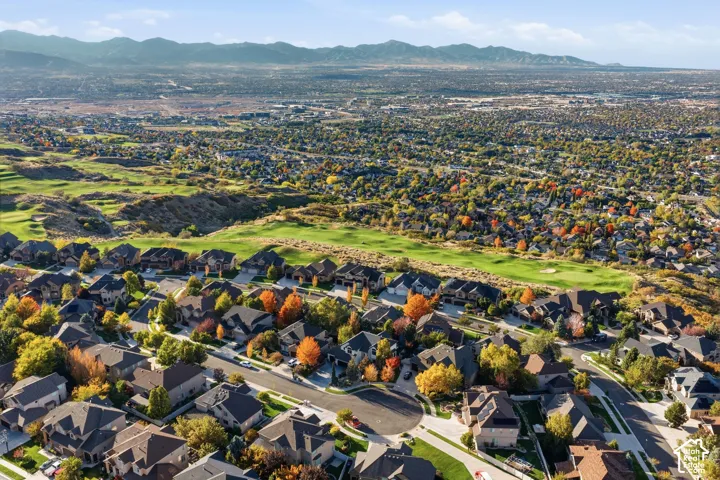 Aerial perspective of a suburban neighborhood featuring expansive mountain range horizons and direct proximity to a golf course