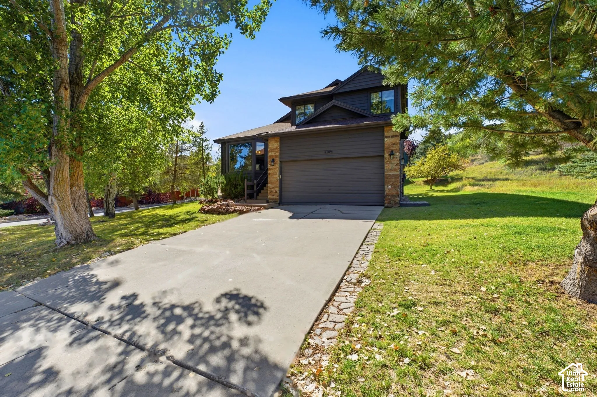 Two-story residence with a two-car garage, stone column accents, and a concrete driveway