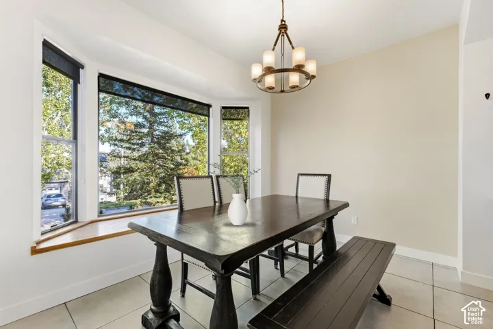 Bay window with wood-finish sill, contemporary chandelier, and tile flooring