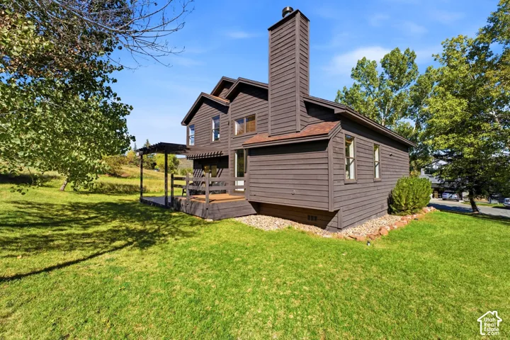 Siding exterior with multiple windows, an attached deck, and pergola