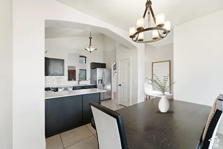 Kitchen featuring dark cabinetry, stainless steel appliances, a subway tile backsplash, and light countertops