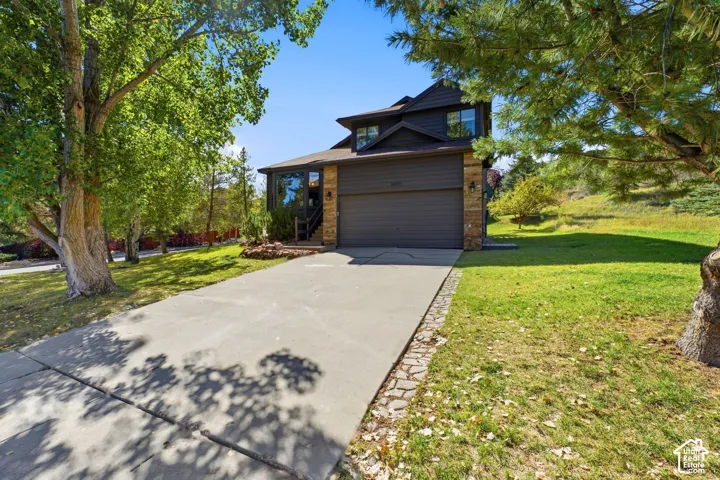 Two-story residence with a two-car garage, stone column accents, and a concrete driveway