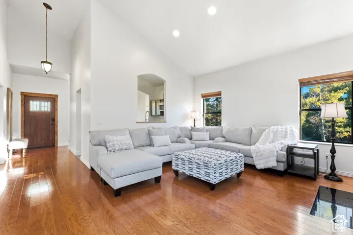 Vaulted ceilings, recessed lighting, wood-finish flooring, and a transom window above the entry door