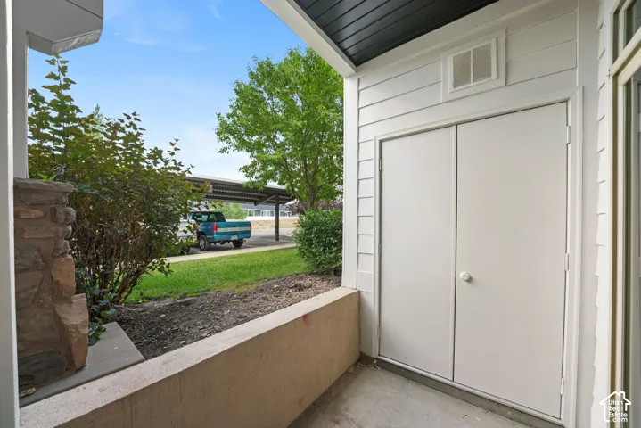 Outdoor storage closet with dual doors, concrete patio, and horizontal siding