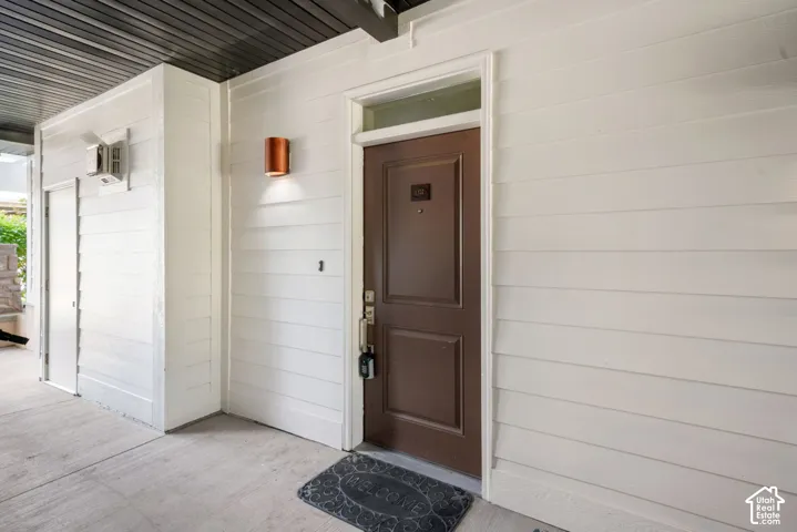 Siding exterior with a dark wood-finish entry door, framed by white trim