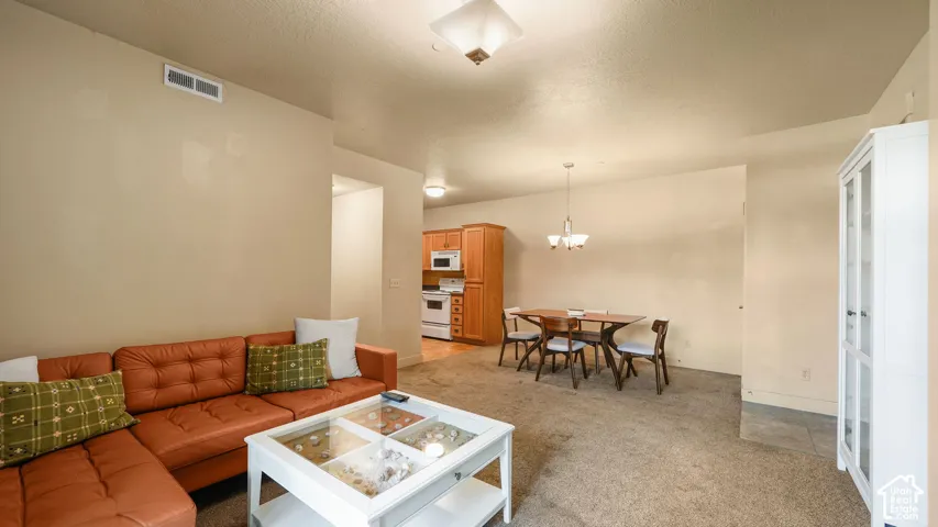 Open layout with carpet flooring, recessed lighting, and a kitchen featuring wood-finish cabinetry