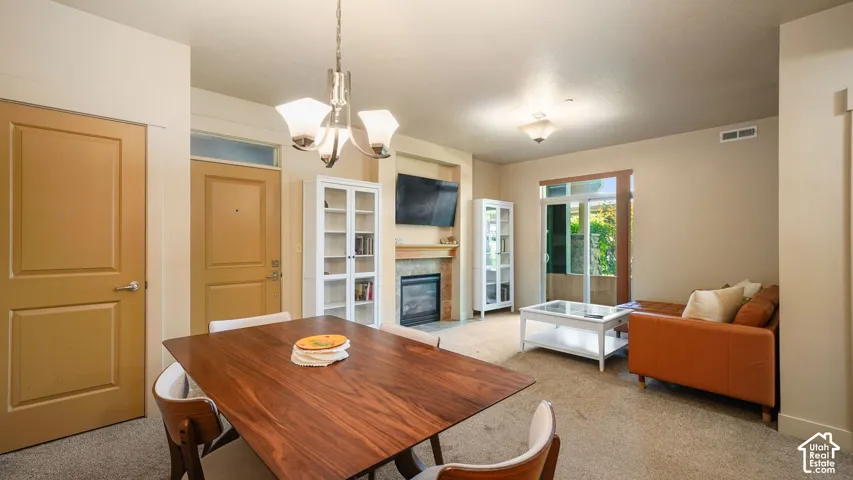 Warm wood-finish dining table with modern seating, complemented by a contemporary chandelier