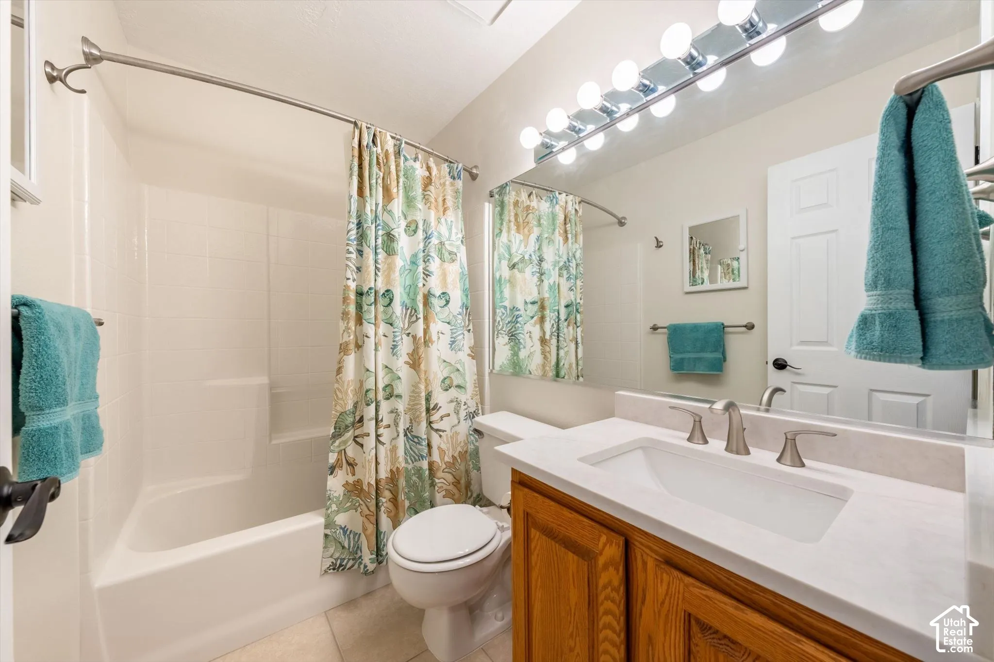 White integrated sink with brushed nickel faucet, wood-finish vanity, and full-width mirror