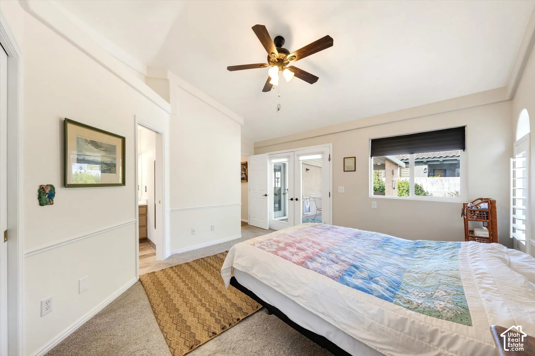 Vaulted ceiling, ceiling fan with light fixture, carpeted flooring, French doors, and window with plantation shutters
