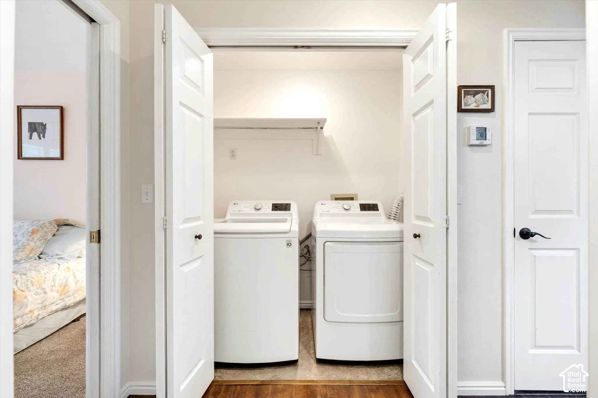 Built-in laundry closet with bi-fold panel doors and wood-finish flooring