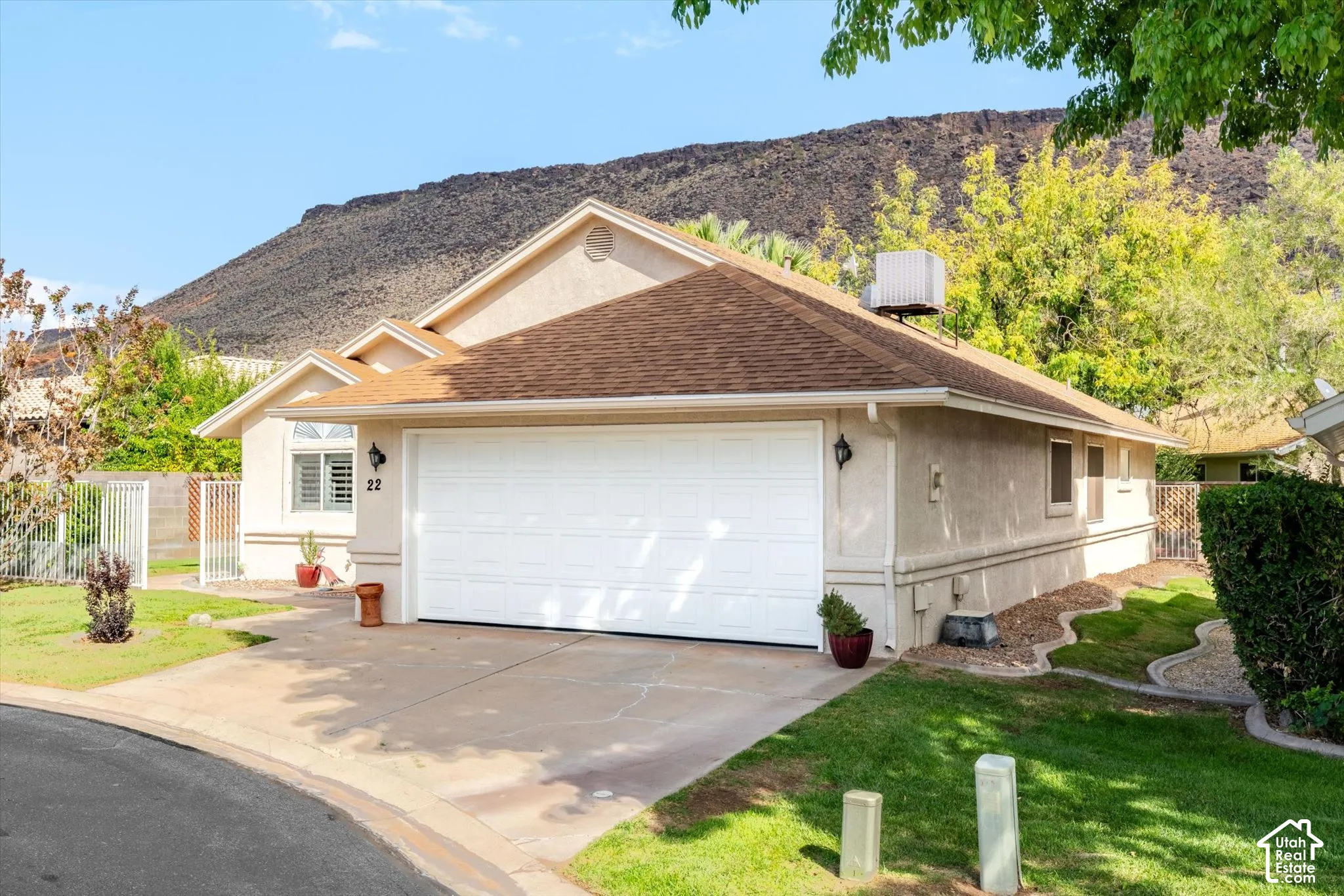 Stucco exterior with a brown shingle roof