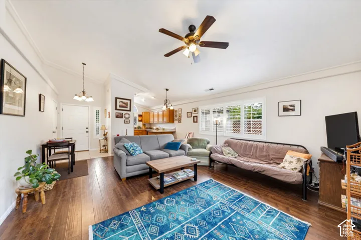 Vaulted ceiling with crown molding, wood-finish flooring, ceiling fan with integrated lighting, window with plantation shutters, and recessed lighting