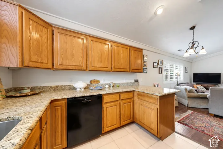 Kitchen featuring wood cabinetry, granite countertops, an undermount sink, and a built-in dishwasher