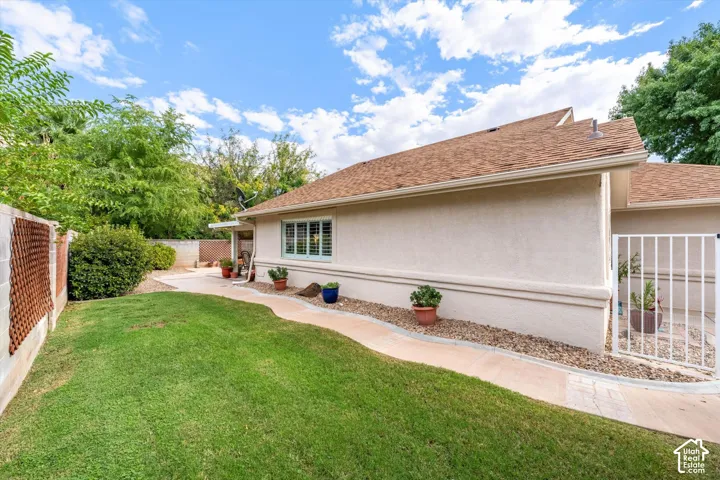 Manicured lawn with a curved concrete pathway and a stucco exterior
