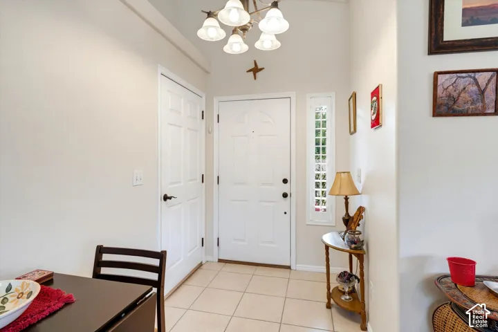 Entryway featuring a white paneled door, a full-length sidelight, and ceramic tile flooring