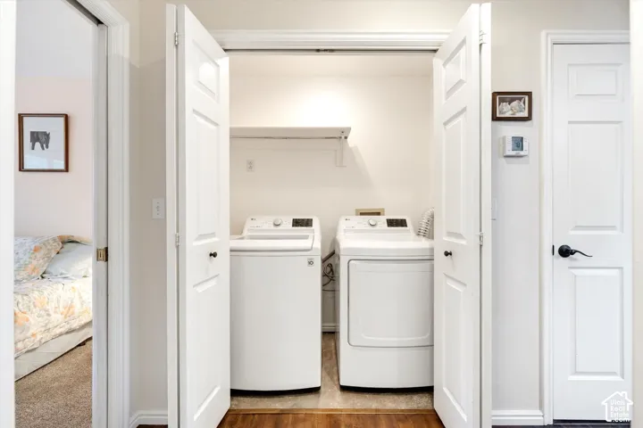 Built-in laundry closet with bi-fold panel doors and wood-finish flooring