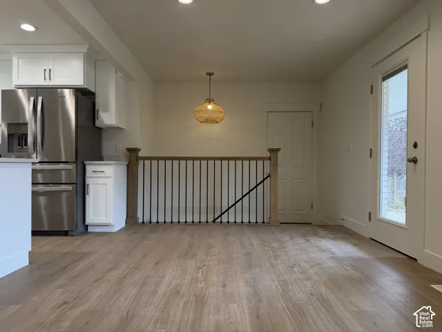 Wood-finish flooring throughout, bright recessed lighting, and a modern pendant light fixture
