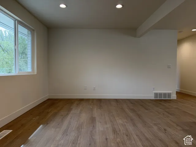 Wood-finish flooring, recessed lighting, white trim, and a white window frame