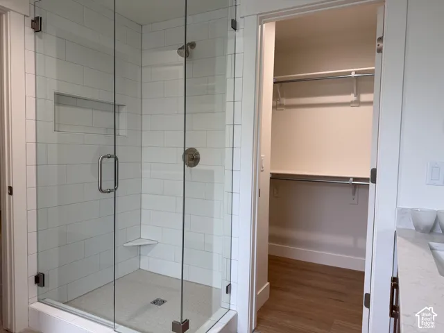 Clear glass shower enclosure with subway tile surround, integrated shower bench, and a brushed nickel shower head